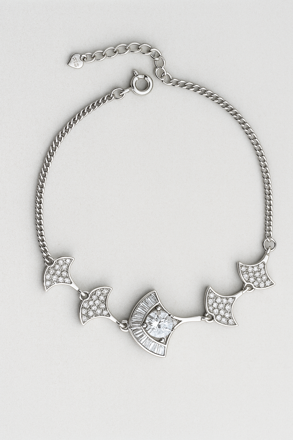 Silver bracelet with decorative elements on a light gray background