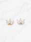 A pair of gold butterfly stud earrings with marquise-cut clear crystals, displayed on a white marble background.