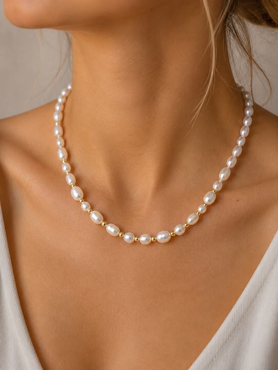 Pearl necklace worn by a person with a neutral background