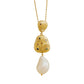 A gold pendant necklace featuring three stacked, textured gold charms with tiny colored gemstones and a large, teardrop-shaped white baroque pearl hanging below, set against a plain white background.