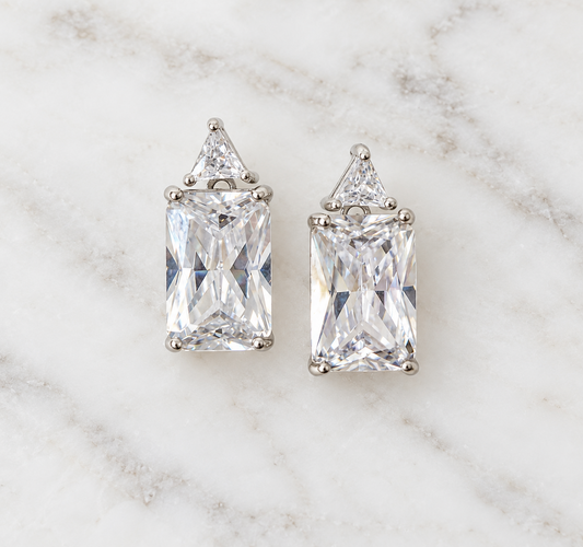 Sterling silver rectangular and triangular cubic zirconia stud earrings on white marble